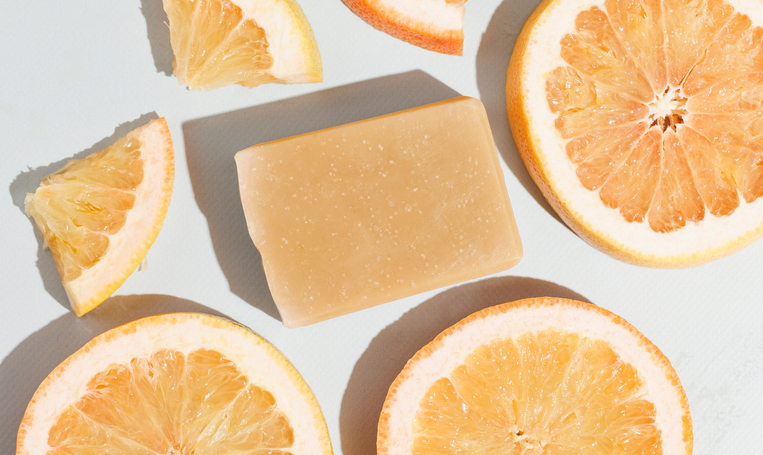 Bar of soap laying flat with slices of grapefruit